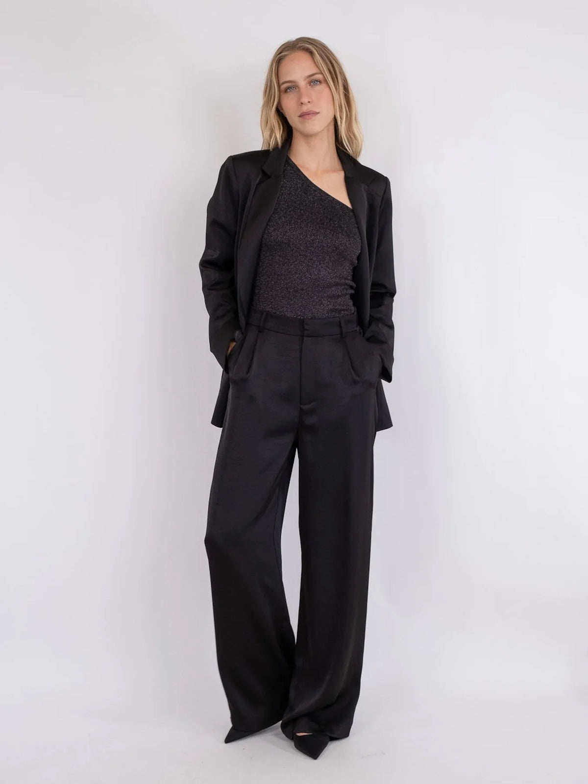 Model wearing Neo Noir Alessandra Heavy Sateen Pants – Black with a stylish blazer, showcasing women's fashion from premium brands.