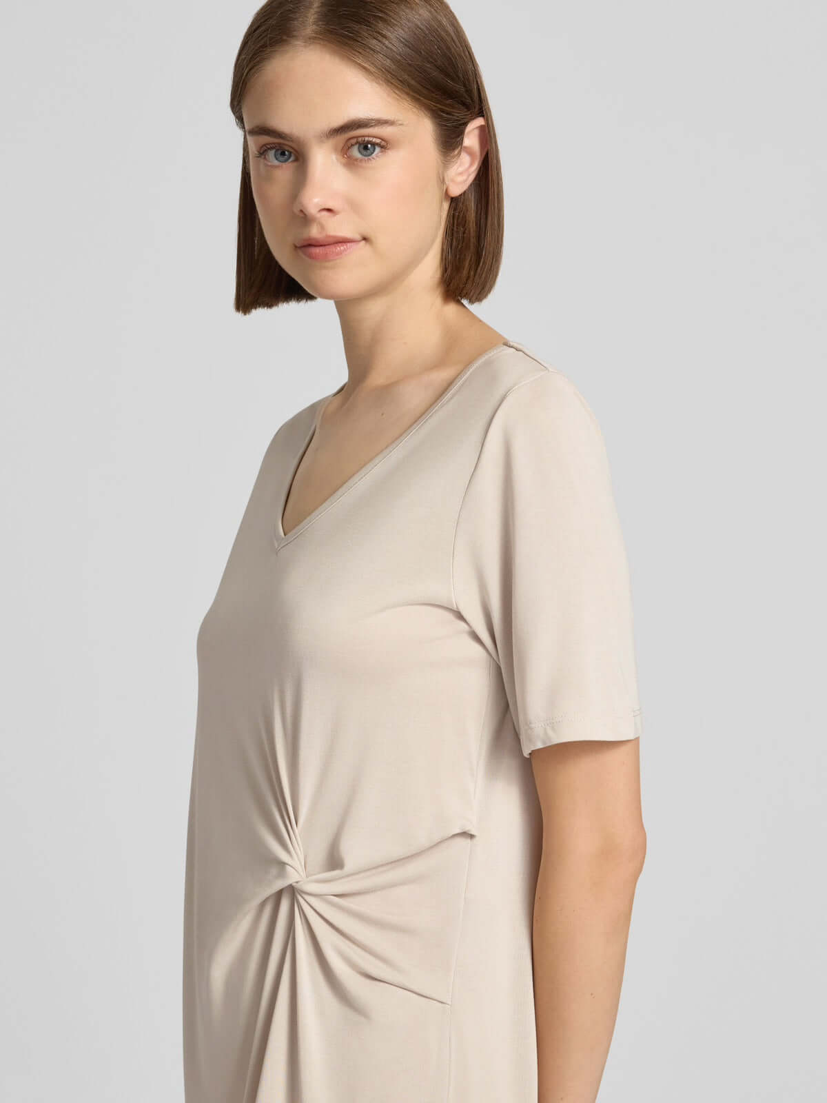Pieces Pcanora Short Dress in beige, women's fashion with short sleeves, asymmetric drape, and twist-knot detail.
