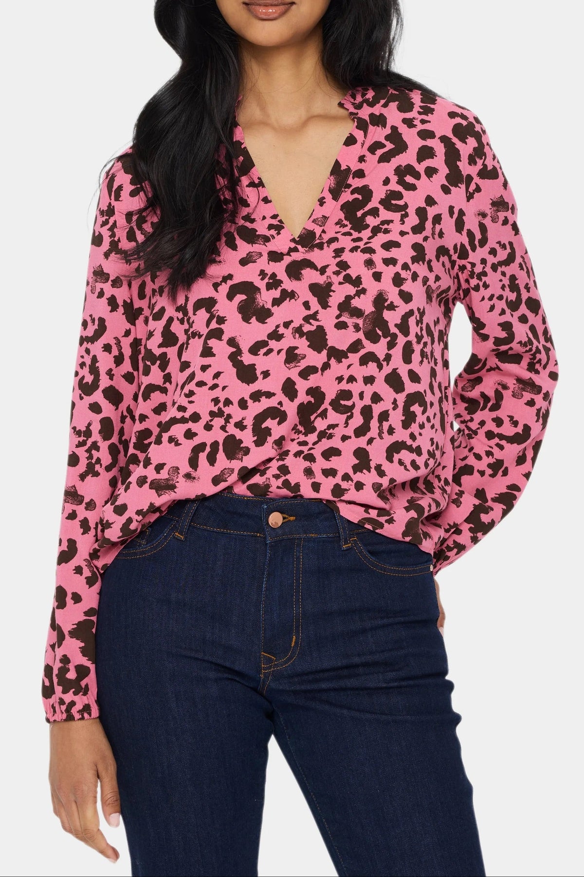 Saint Tropez EDASZ pink animal print blouse on a model with dark blue jeans, showing the V-neck, long sleeves and front fit.